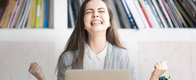 happy woman cheering at desk