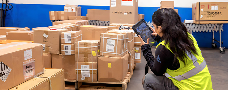 worker kneeling down organizing freight for a logistics company