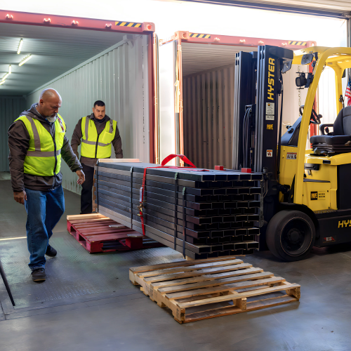 Warehouse workers loading a container with a forklift