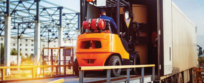 Forklift is putting cargo from warehouse to truck outdoors