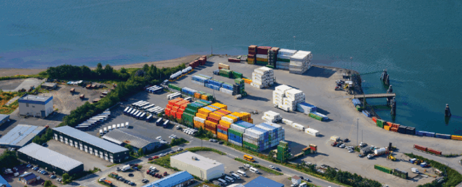 Juneau, Alaska - August 24, 2023 : Aerial view of the commercial port of Juneau, Alaska - Shipping containers piled on a polder in a remote location in the American arctic